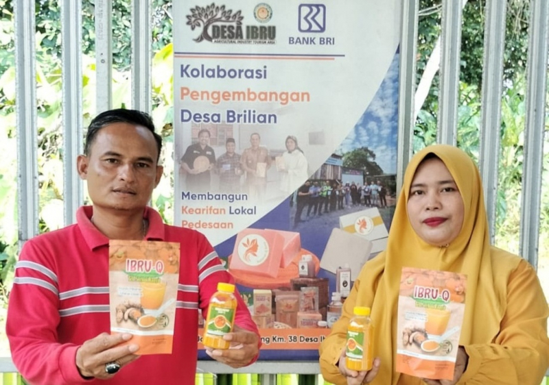 Kepala Desa Ibru  Arman didampingi Ketua Kelompok Wanita Tani (KWT) Desa Ibru, Rusmaini saat memperlihatkan hasil olahan kunyit yang menjadi andalan desa mereka.