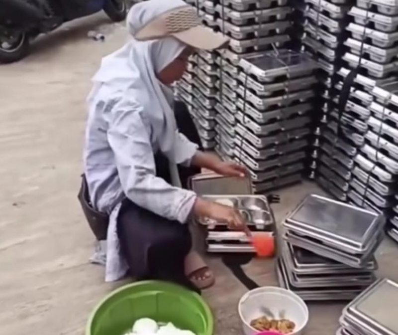 Tangkan layar sebuah video amatir yang memperlihatkan seorang ibu mengumpulkan sisa makanan program Makan Bergizi Gratis (MBG) di kawasan Sawangan, Kota Depok