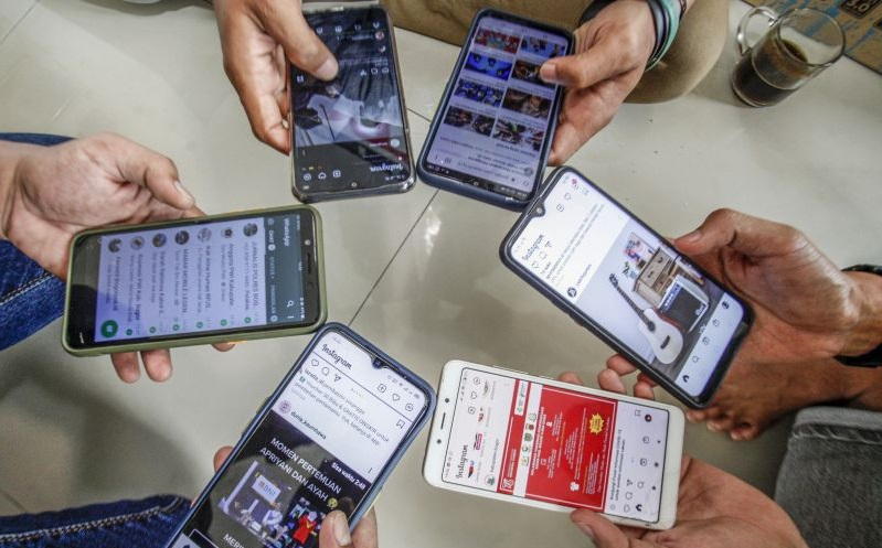 Warga mengakses internet dari perangkat ponsel mereka di Bogor