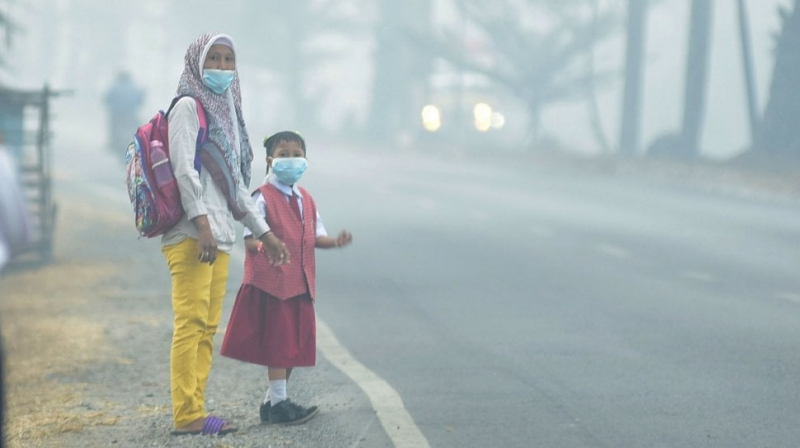 Warga menggunakan masker saat keluar rumah