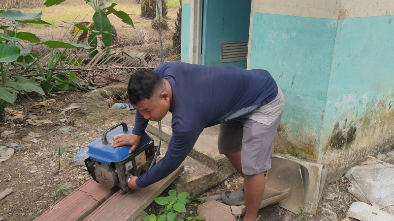 Salah satu warga saat berusaha menghidupkan mesin gensetnya untuk kebutuhan elektroniknya saat di siang hari